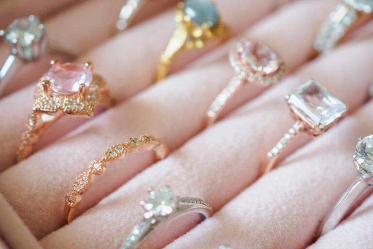 A couple’s hands together, each wearing distinctive, modern wedding bands with mixed metals and subtle texture.
